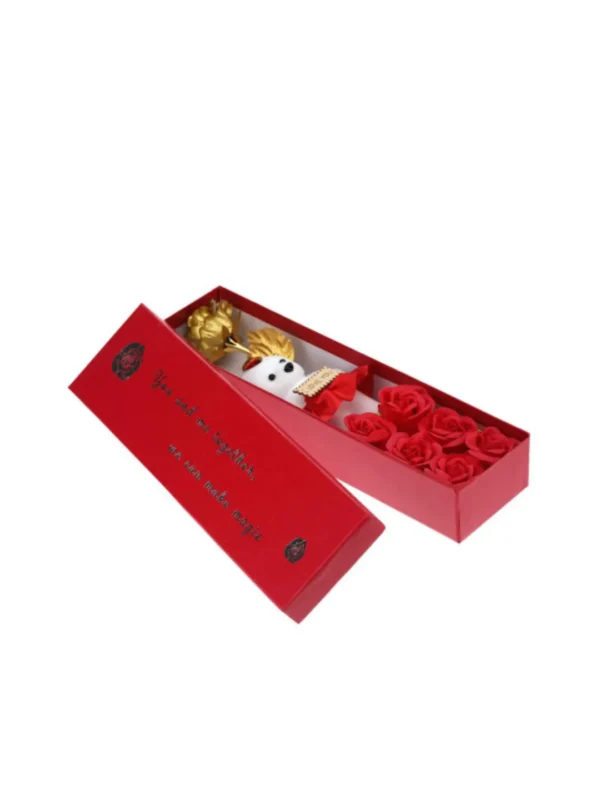 Open red gift box showing Valentine gift hamper with golden artificial rose, mini teddy bear and red soap flower arrangement