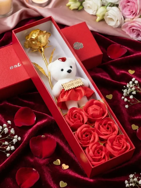 Valentine's Day gift set for girlfriend with golden rose, teddy bear and red soap flowers in luxury red box on silk fabric